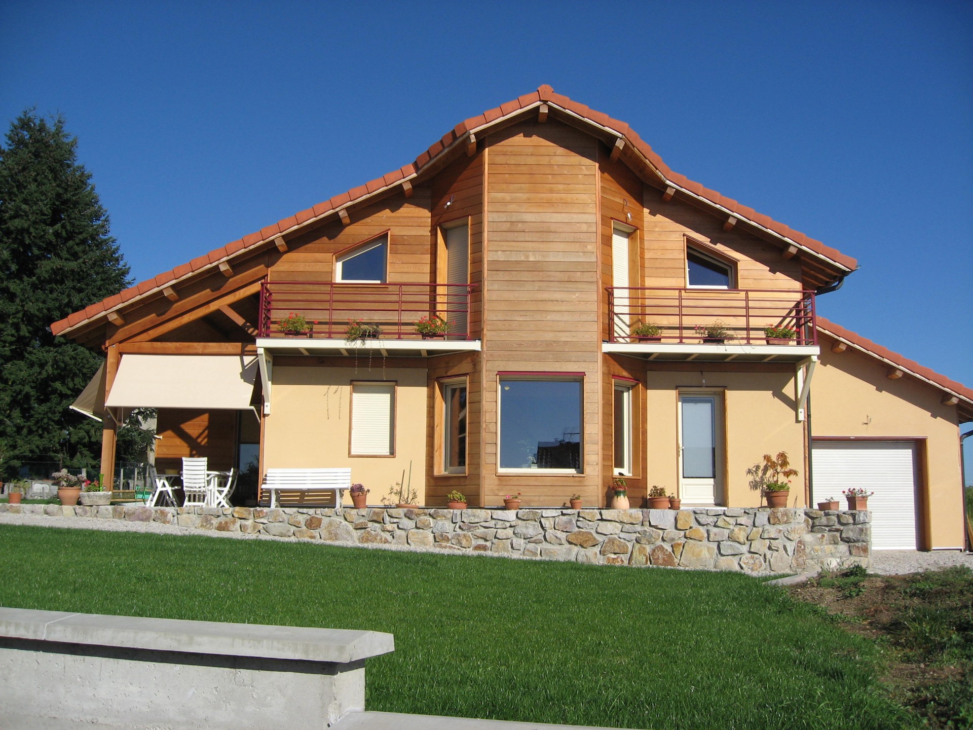 Maison ossature bois Haute-Loire (43) — chalet bois avec bardage clair, balcons et tuiles rouges
