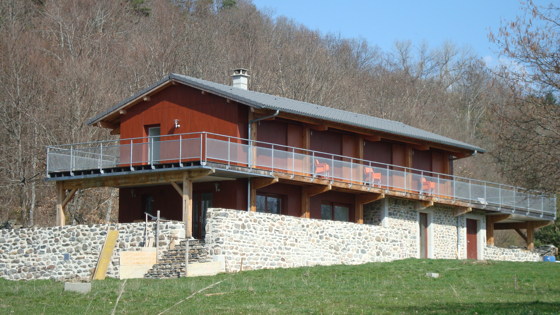 Maison ossature bois à Yssingeaux — chalet bois et bardage rouge avec terrasse