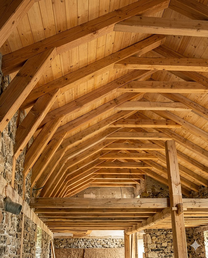 Charpente en bois rénovée en Haute-Loire — chevrons et pannes apparents
