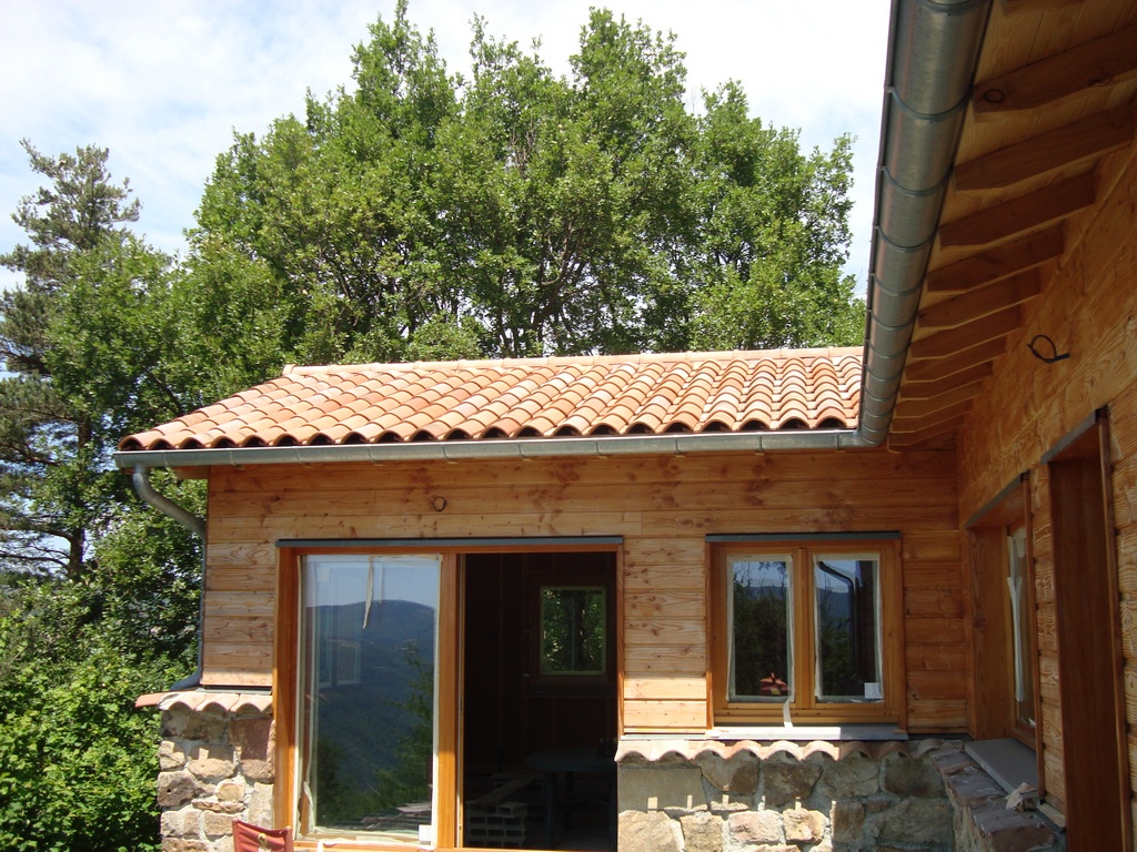 Maison ossature bois à Yssingeaux — bardage bois clair et toiture tuiles canal