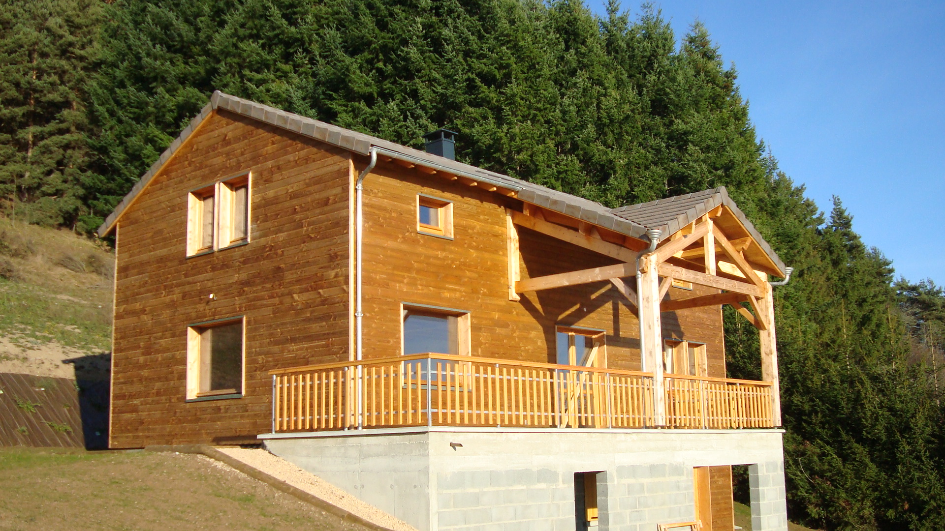Maison ossature bois Haute-Loire (43) — chalet bois avec balcon en lisière de forêt
