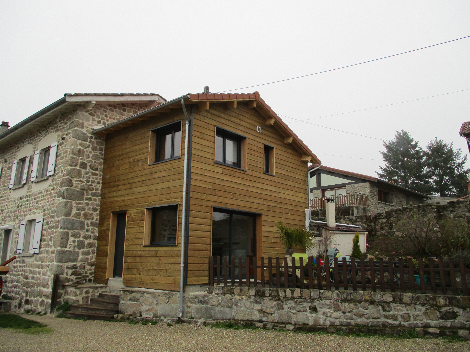 Maison ossature bois à Yssingeaux — façade bois en extension d'une maison en pierre